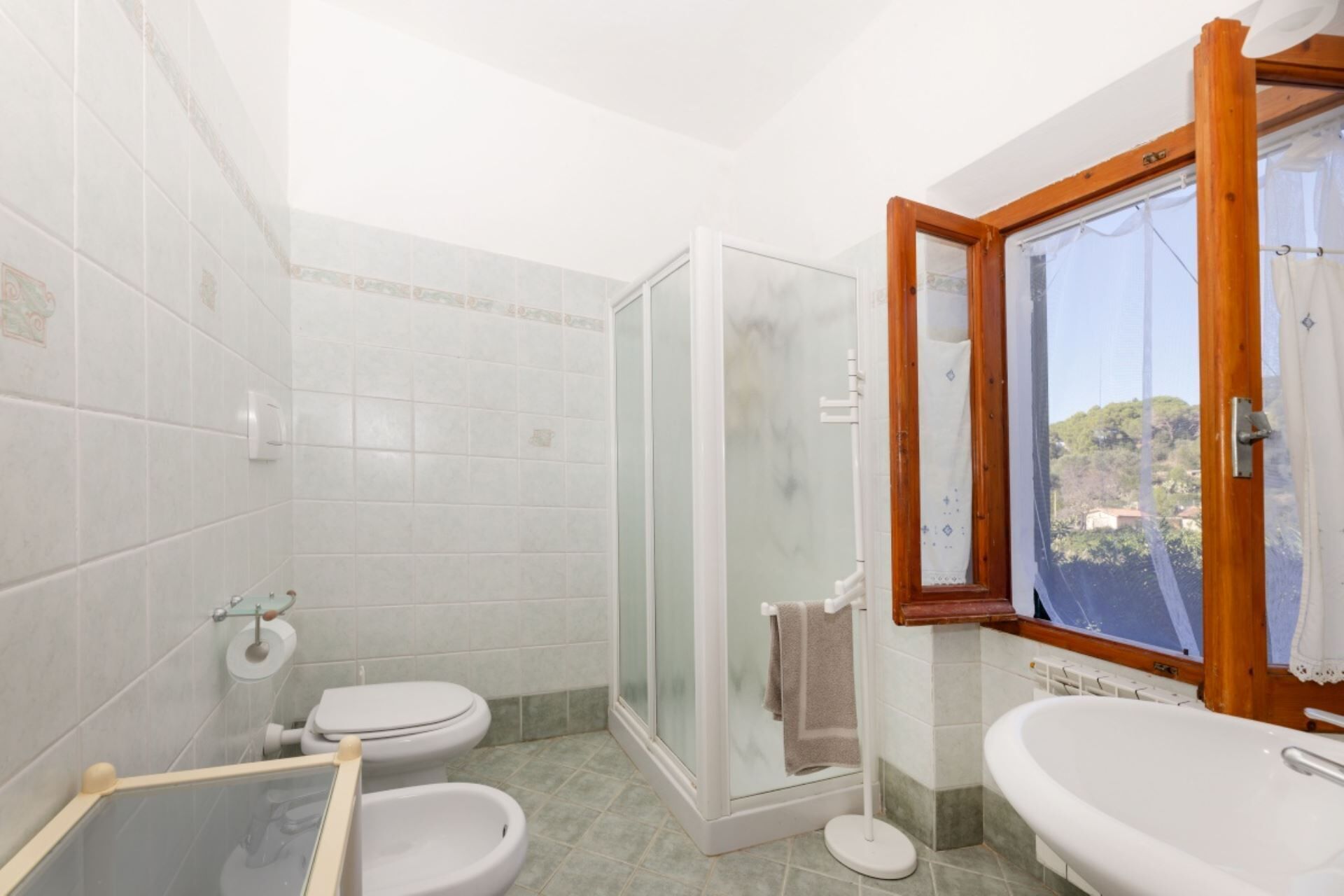 Une salle de bain avec douche, toilettes et lavabo.