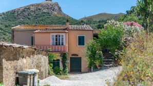 Un bâtiment à deux étages doté d’un balcon, d’une porte et d’un escalier menant à un porche.