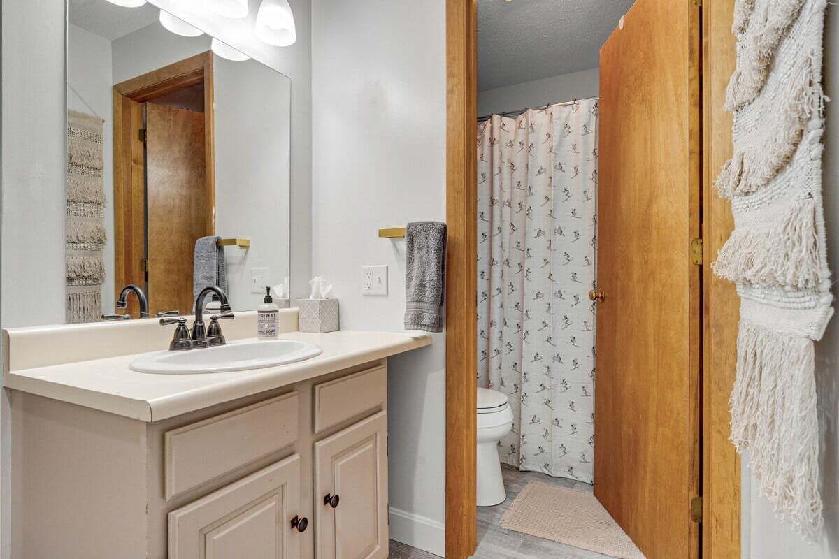 A bathroom with a sink, mirror, and toilet.