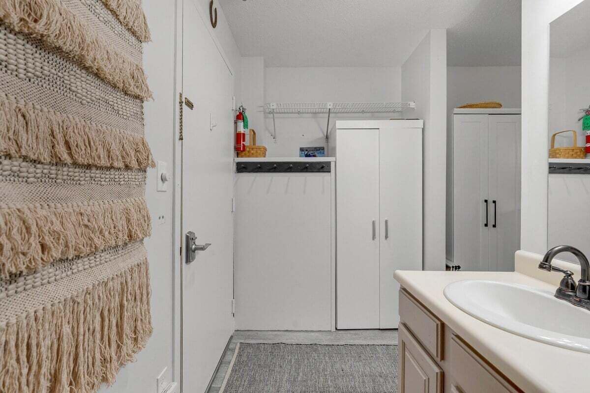 A bathroom with a sink, mirror, and cabinets.