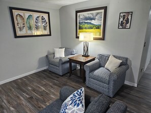 A living room with two patterned armchairs, a small table with a lamp, and framed artwork on the walls. - Outskirts of Gatlinburg, Minutes to everything 3-bedroom apartment in Gatlinburg (Gatlinburg)