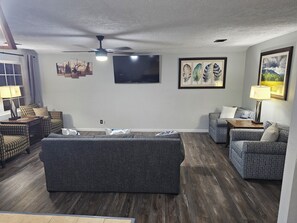 A living room with a grey sofa, patterned armchairs, a flat-screen TV, and framed artwork on the walls. - Outskirts of Gatlinburg, Minutes to everything 3-bedroom apartment in Gatlinburg (Gatlinburg)