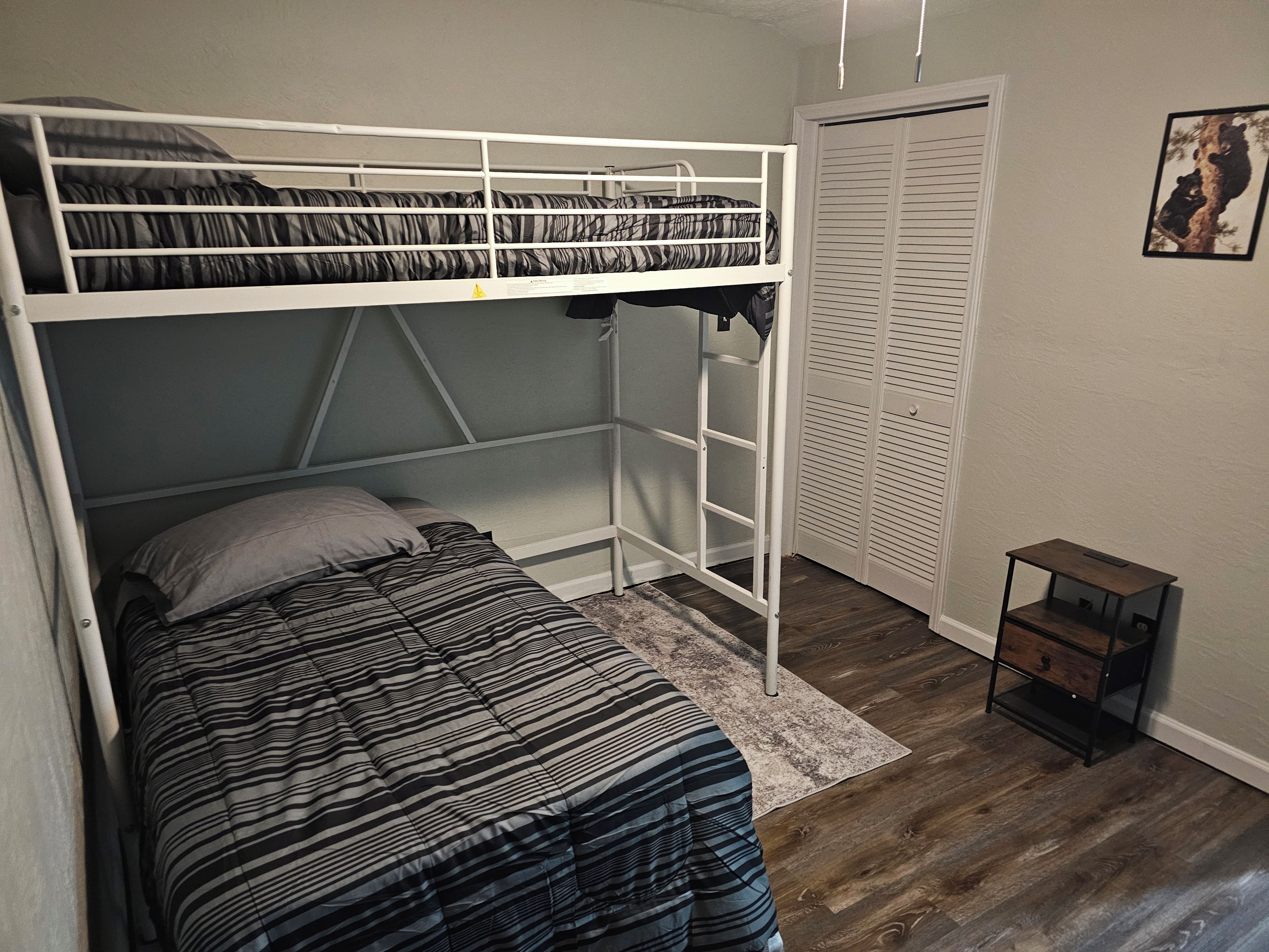 A bunk bed with a lower bed and a wardrobe with louvered doors.