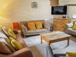 A living room with a sofa, a wooden coffee table, a TV, and a dresser. - 5 bedroom accommodation in Umberleigh (Umberleigh)