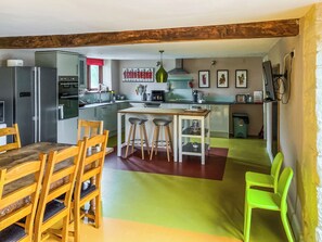 A kitchen with wooden chairs, a dining table, and a bar area. - 5 bedroom accommodation in Umberleigh (Umberleigh)