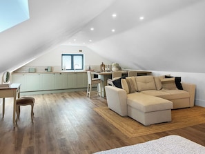 Un espacio habitable tipo loft con comedor, cocina y un amplio ventanal.
