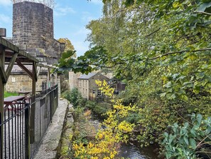 Een stenen brug, een rivier en gebouwen met traditionele architectuur.