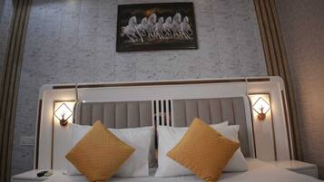 A neatly made bed with two pillows, a headboard with built-in lighting, and a painting of horses on the wall.