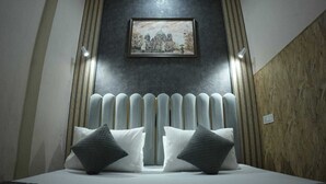 Un dormitorio moderno con una cama grande, un radiador y un cuadro enmarcado en la pared.