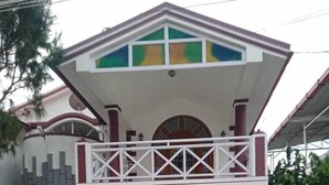A two-story house with a balcony, a gated entrance, and a staircase leading to the front door. - Sunshine Royale (Kodaikanal)