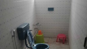 A small bathroom with a toilet, a bidet, a sink, and a window. - Sunshine Royale (Kodaikanal)