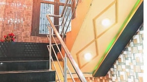 Eine Treppe mit Metallgeländer, eine Holztür mit Glasschränken und eine geflieste Wand.