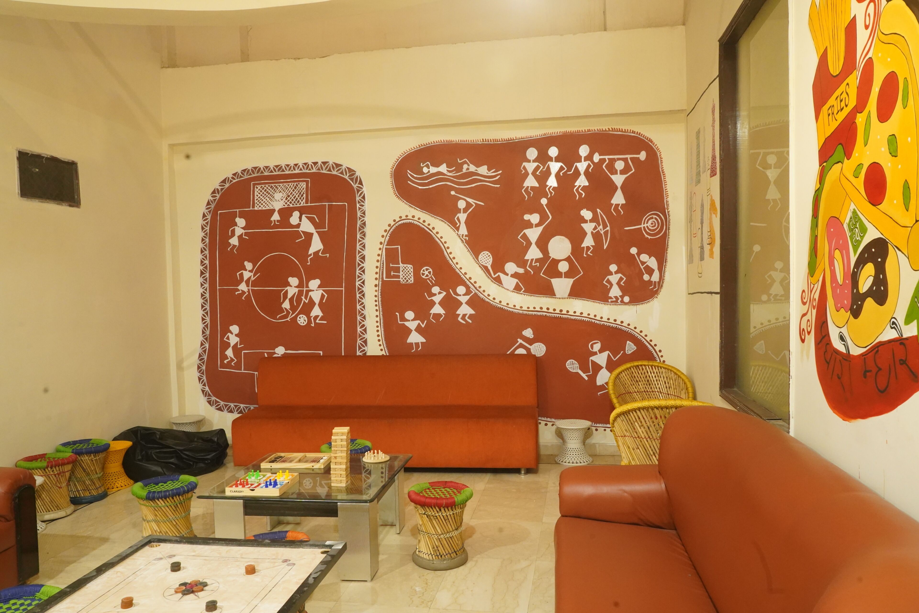 A living room with a sofa, coffee table, and a wall mural.