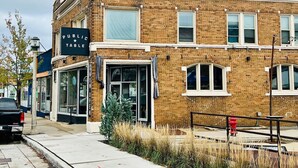 A brick building with a storefront labeled "PUBLIC TABLE." - Babich Building - 3 Bedroom - Upper Apt #4 (West Allis)