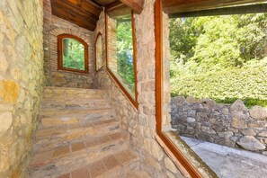 Eine Steintreppe mit Holzgeländern und Rundbogenfenstern.