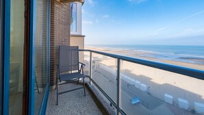 A balcony with a chair, a view of the beach, and a clear sky. - Apartment on the 6th floor with sea view (Middelkerke)