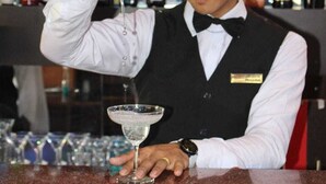 A bartender pouring a drink into a martini glass. - Hotel Quick Twenty And Riverside (Jitpur Simara)