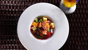 A white plate with a colorful salad on a dark woven tablecloth. - Hotel Quick Twenty And Riverside (Jitpur Simara)