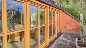 Una casa moderna con ampie vetrate e un patio in pietra.