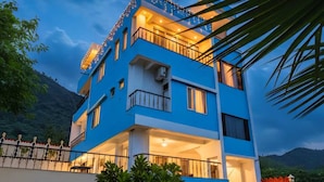 A multi-story building with balconies, a staircase, and outdoor seating.