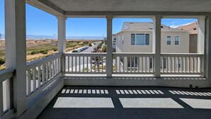 A covered porch with a view of a residential street and houses. - Spacious 4-bedroom house in charming Newark with AC (Newark)