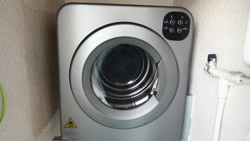 A compact, modern washing machine with a control panel on the top right.