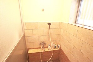 Regadera, secadora de cabello, pantuflas, toallas 