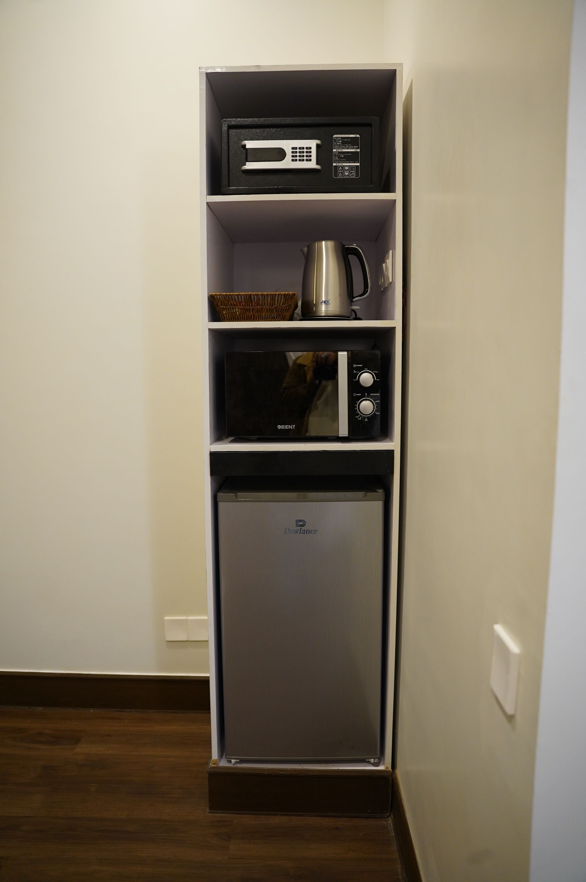 A compact kitchenette with a microwave, coffee maker, and refrigerator.