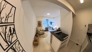 A modern kitchen with a built-in stove and a dining area with a table and chairs. - Studio Safe & Modern • 5 min Ferry to Rio• 1Gbps Wi-Fi • Pet & Kid-Friendly (Niterói)
