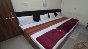 Ein Hotelzimmer mit einem Bett, einem Nachttisch, einem Stuhl und einem Badezimmer mit Waschbecken.