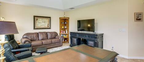 A living room with a sofa, a coffee table, a television, and a bookshelf.