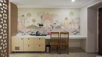 Una habitación con escritorio, silla y un mural decorativo en la pared.