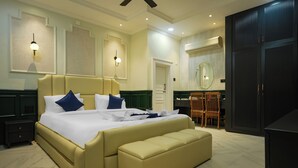 A large bed with a headboard, a bench, a nightstand, a mirror, a wardrobe, and a chair. - The Forest Hills Resort (Sarada)