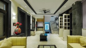 A modern interior with a sofa, a coffee table, a decorative vase, and a television. - The Forest Hills Resort (Sarada)