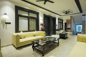 Habitación Deluxe, balcón | Área de sala de estar