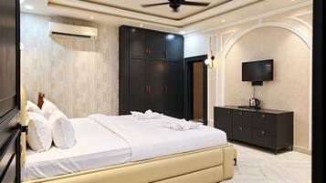 Un dormitorio moderno con cama, armario, televisión y ventilador de techo.