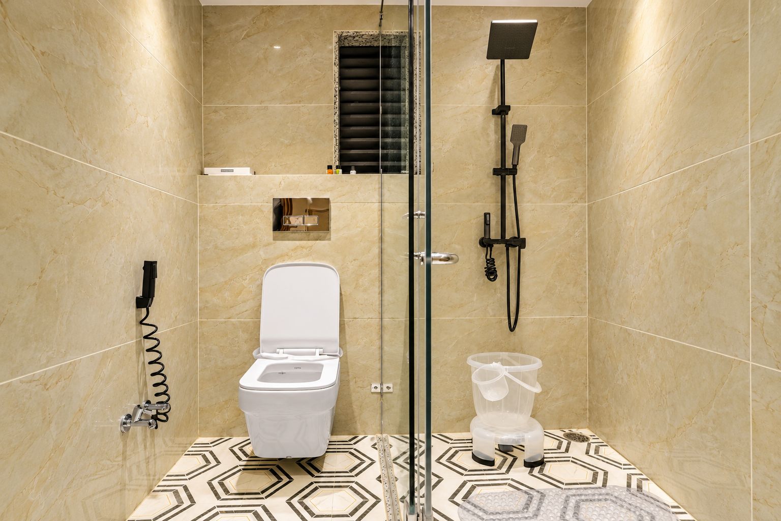 Un baño moderno con ducha de vidrio, inodoro y bidé.
