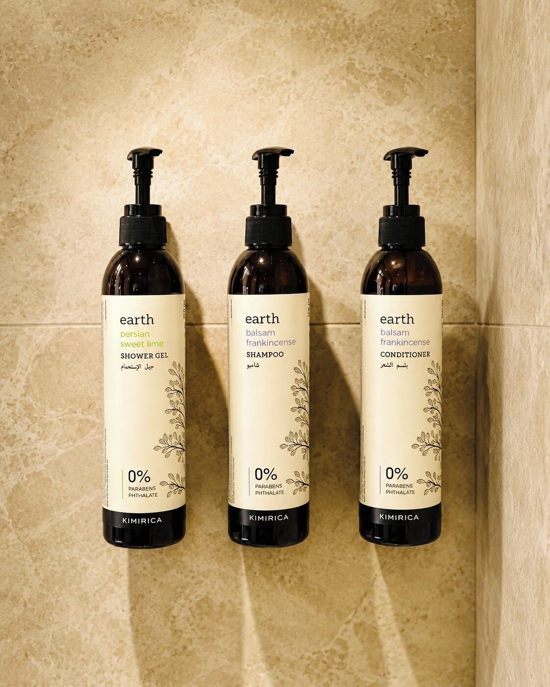 Three bottles of Earth brand products on a tiled wall.