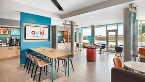 A modern hotel lobby with a reception desk, seating area, and large windows offering a view. - Avid Hotel Fresnillo (Fresnillo)