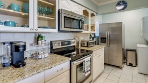 A modern kitchen with white cabinetry, stainless steel appliances, and a granite countertop. - Pool Access + Views: Waterfront Lake Conroe Escape (Montgomery)