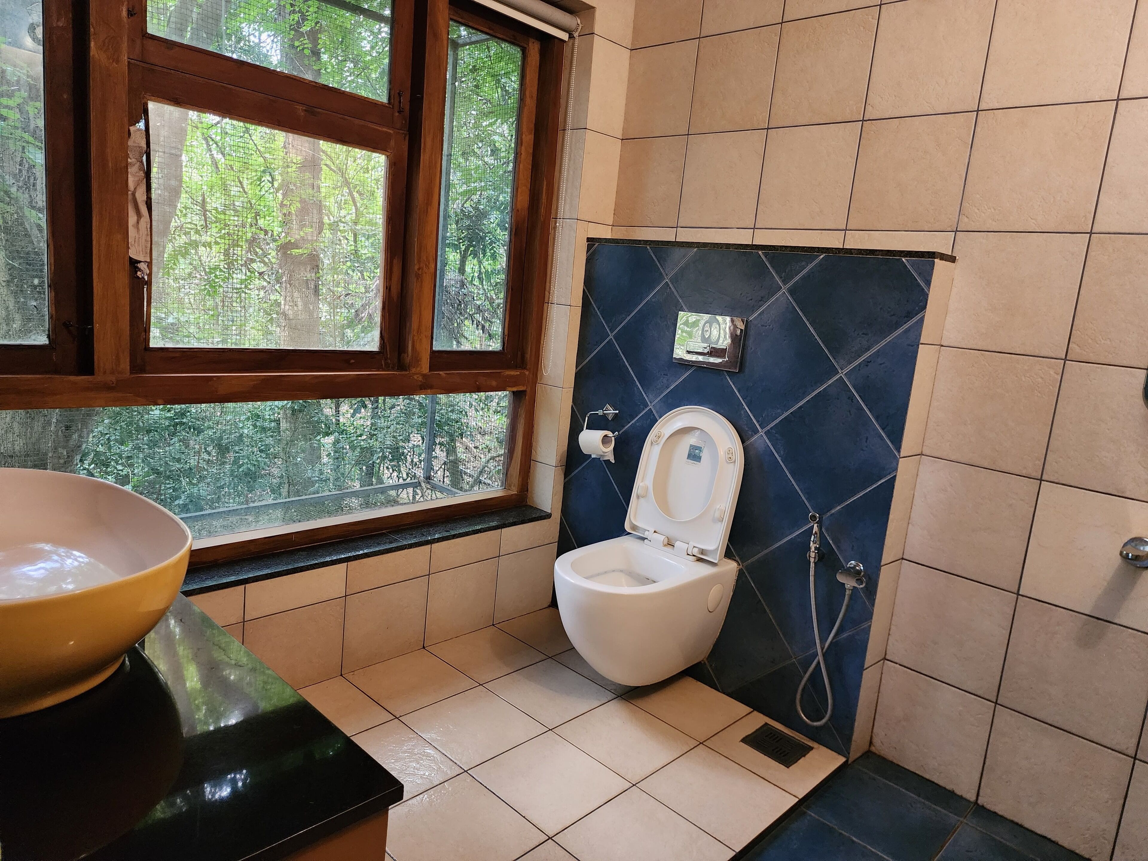 Un baño con inodoro, lavabo y ventana.