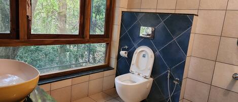 Un baño con inodoro, lavabo y ventana.