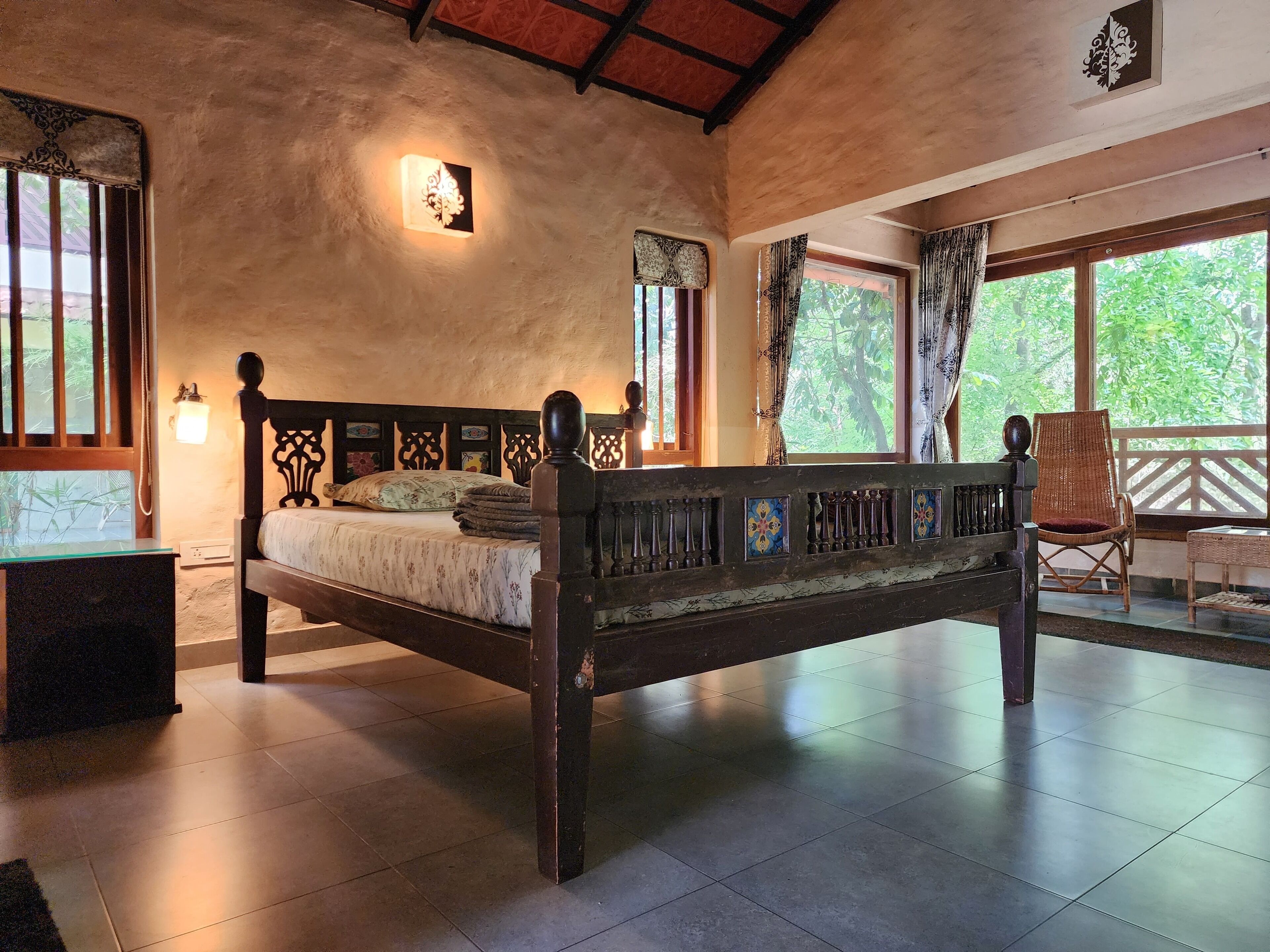 A bedroom with a wooden bed, a nightstand, and a window with curtains.