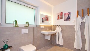 Ein modernes Badezimmer mit Toilette, Waschbecken und Handtuchhalter.