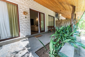 A covered outdoor area with a stone floor, a wooden ceiling, and a brick wall. - Bellevue Beach Nilaveli BY PARADISE COLLECTION (Nilaveli)
