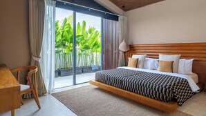 A bedroom with a large bed, a wooden headboard, a desk, and a view of greenery through a sliding door. - Villa Rosa by Pertama Stay (Kerobokan)