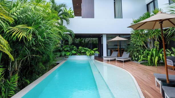 A modern house with a swimming pool, surrounded by lush greenery. - Villa Rosa by Pertama Stay (Kerobokan)