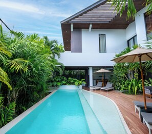 A modern house with a swimming pool, surrounded by lush greenery. - Villa Rosa by Pertama Stay (Kerobokan)