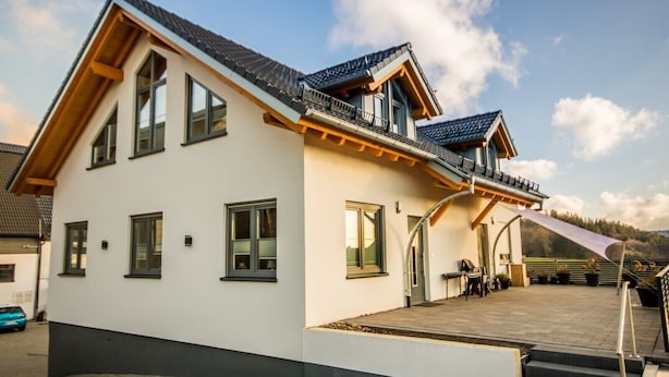 A modern two-story house with a balcony, large windows, and a covered outdoor area. - Apartment 'Stratmann' with Shared Terrace and Wi-Fi (Lennestadt)