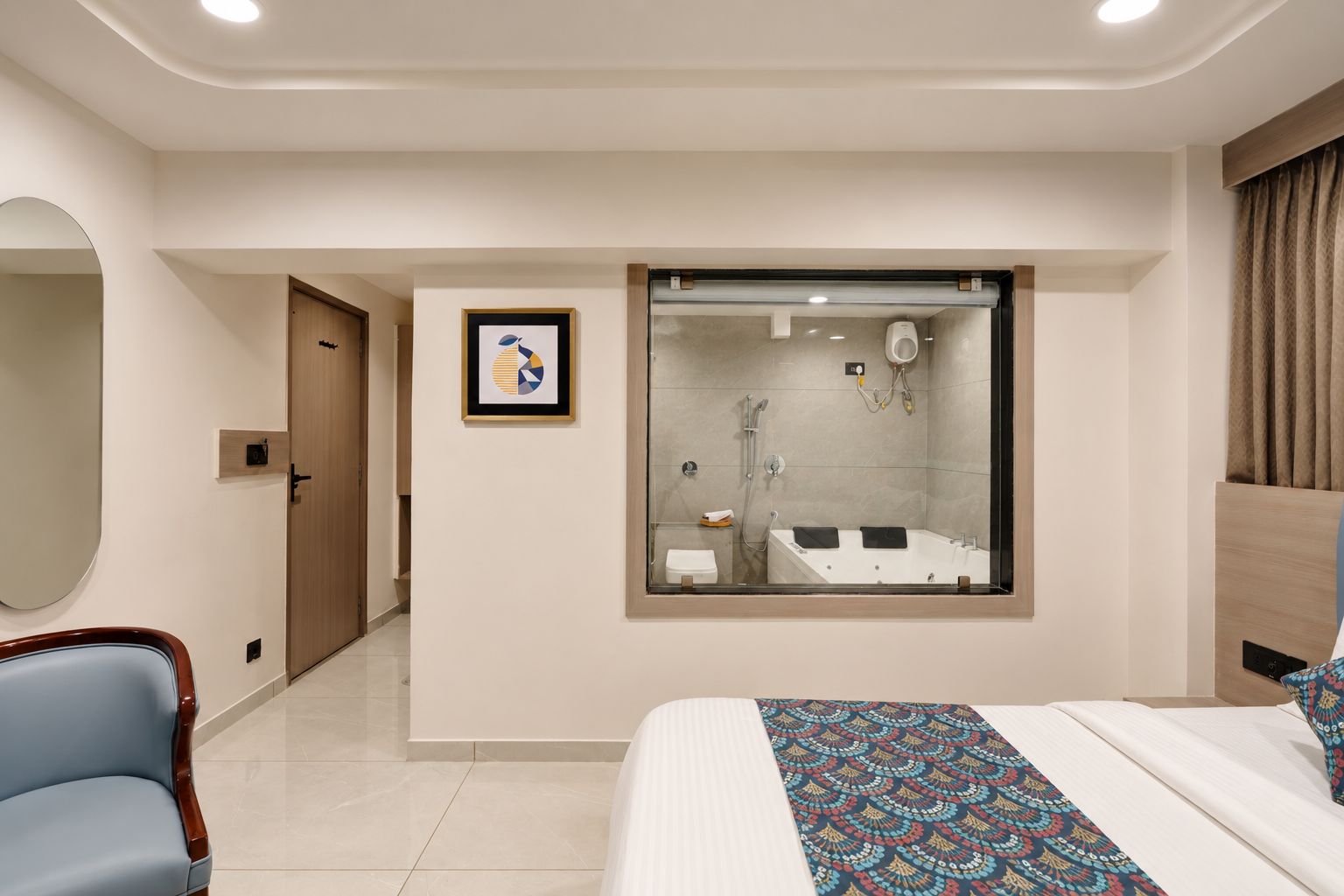 Een hotelkamer met een groot bed, een badkamer met een douchecabine van glas en een ingelijst kunstwerk aan de muur.